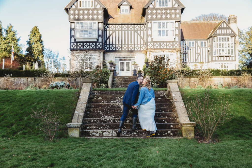 newly married couple kissing on the steps of a manor house in hull after planning a wedding in Hull